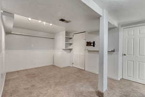 Carpeted empty room with a textured ceiling