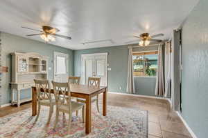 Flexible family room featuring light tile patterned flooring and ceiling fan