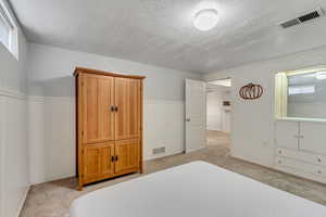 Carpeted bedroom featuring a textured ceiling