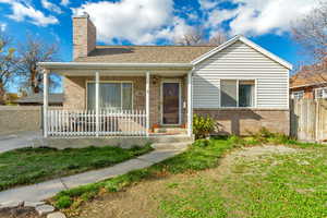 View of front of house with a porch and a front lawn