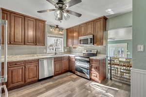 Kitchen featuring spacious counters, stainless steel appliances, decorative backsplash, sink, and light hardwood / wood-style floors