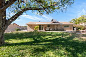 Rear view of property featuring a patio, a lawn, and cooling unit