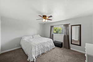 Bedroom featuring carpet flooring, a textured ceiling, and ceiling fan