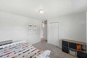 Bedroom with a closet and light colored carpet