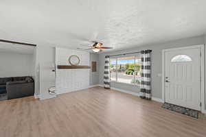 Entryway featuring light wood-type flooring, a textured ceiling, and ceiling fan