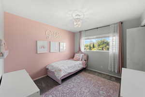 Bedroom with light carpet and a notable chandelier