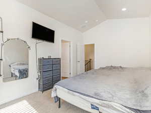 Bedroom with lofted ceiling and carpet