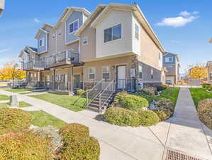 View of property with a front yard and a balcony