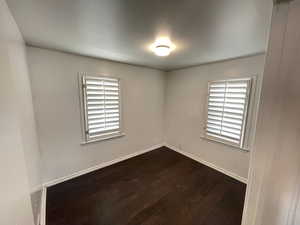 Empty room featuring dark wood-type flooring