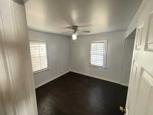 Unfurnished room featuring ceiling fan and dark hardwood / wood-style floors