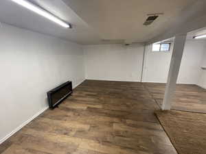 Basement with dark hardwood / wood-style flooring and a textured ceiling