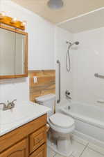 Full bathroom with toilet, vanity, tile patterned floors, and bathtub / shower combination