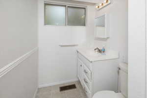 Bathroom with toilet, vanity, and tile patterned floors