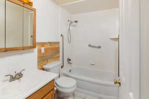 Full bathroom with toilet, vanity, shower / tub combination, and tile patterned floors