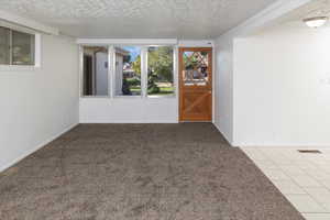 Spare room with a textured ceiling and carpet flooring