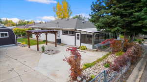 Rear view of property with a sunroom, a patio, a pergola, and central AC