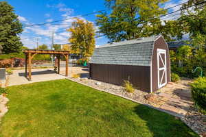 View of yard featuring cooling unit, a storage unit, and a patio