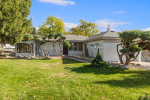 View of front facade with a front yard and a sunroom