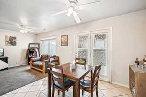 Tiled dining room with ceiling fan, plenty of natural light, and a textured ceiling