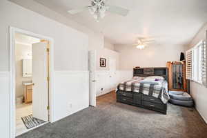 Carpeted bedroom with ceiling fan and ensuite bathroom