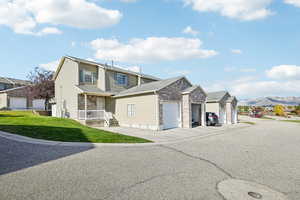 Front facade with a garage, a front yard, and a mountain view