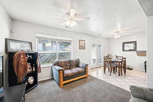 Tiled living room with a textured ceiling and ceiling fan