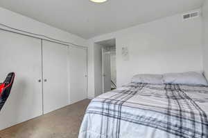 Carpeted bedroom featuring a closet