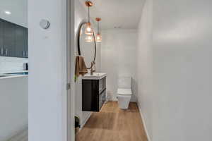 Bathroom featuring hardwood / wood-style floors, vanity, and toilet