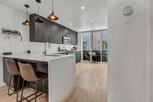 Kitchen with stainless steel appliances, a kitchen breakfast bar, sink, and kitchen peninsula