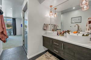 Bathroom with tile patterned flooring, vanity, and a shower with shower door