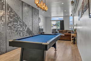 Rec room featuring floor to ceiling windows, light hardwood / wood-style floors, and billiards