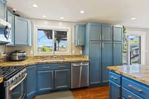 Stainless Steel appliances and pantry cabinets with gorgeous views out of those large windows.