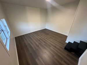 Empty room with dark hardwood / wood-style flooring