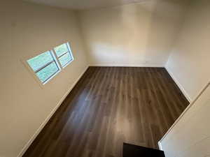 Unfurnished room featuring dark wood-type flooring