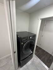 Washroom with light wood-type flooring and washer / clothes dryer