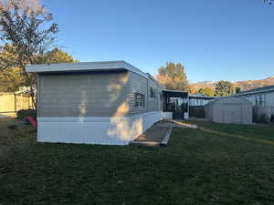 Back of house featuring a lawn, a shed, and a mountain view