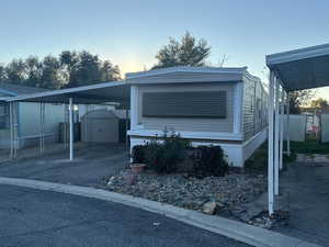 View of front of house featuring a storage shed and a carport