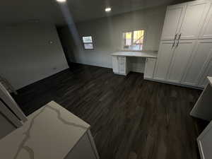 Interior space featuring dark wood-type flooring and built in desk