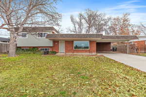 Split level home with a front yard and a carport