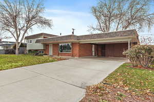 View of front facade featuring a front yard and a carport