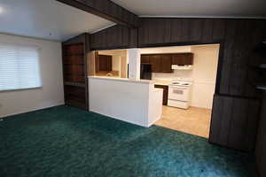 Kitchen Open to Dining Area and Vaulted Family Room Featuring Wood Burning Stove