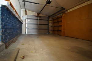 Garage with a garage door opener and built in Shelving