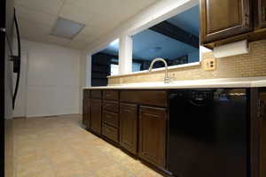 Kitchen with dishwasher, decorative backsplash, and dark brown cabinetry