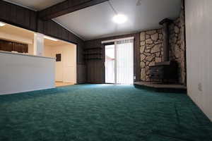 Vaulted Family Room Featuring Wood Burning Stove, and Sliding Glass Door to Covered Deck