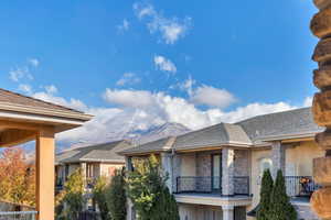 View of front of property with a mountain view and a balcony