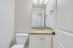 Bathroom with ornamental molding, vanity, and toilet