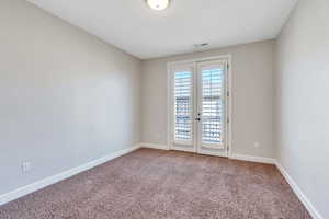 Bedroom featuring french doors and carpet