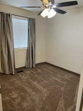 Carpeted empty room with ceiling fan