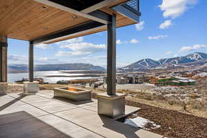 Snow covered patio with a water and mountain view