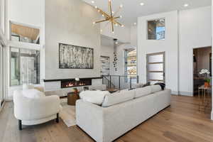 Living room with a towering ceiling, a chandelier, and hardwood / wood-style flooring